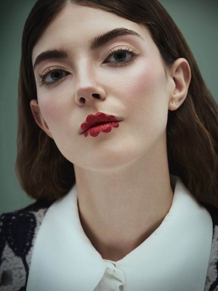 Creative look: deep matte red lip drawn beyond the lip line, bare eyes